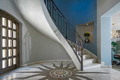 Enter into Casa Buena Vida and be met with an ornate floor design and a beautiful winding staircase