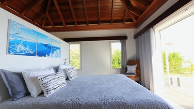 Bedroom 1: Located on one side of the living room. View of the lush tropical environment and the oce