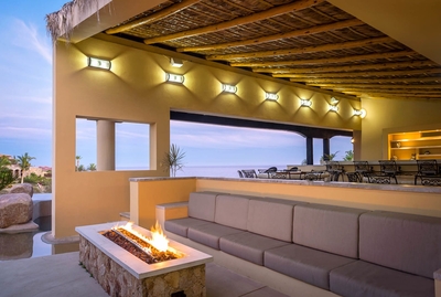 Gather around the modern, large firepit on plush cushions and seating at Casa Tita