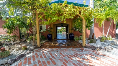 Outdoors: Expansive tropical garden surrounding the property. Private parking at the entrance. 