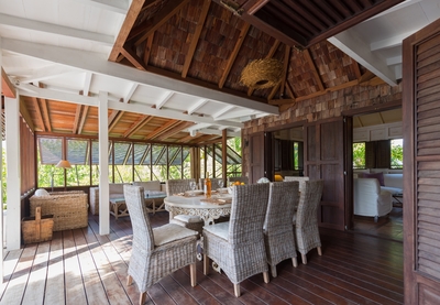 Dining Areas: Opened to the pool and terrace under a wood ceiling, large table and wicker chairs for