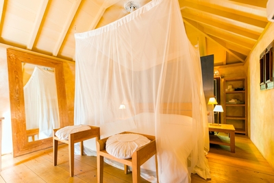 Bedroom 1: Four-poster king bed, mosquito net, air conditioning, separate sitting area with roc