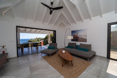 Living Area: Inside living opening widely onto the pool terrace facing the ocean view, furnished wit